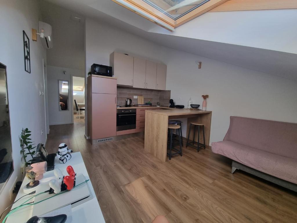 eine Küche und ein Wohnzimmer mit einem Sofa und einem Tisch in der Unterkunft Geek Apartment in Omiš