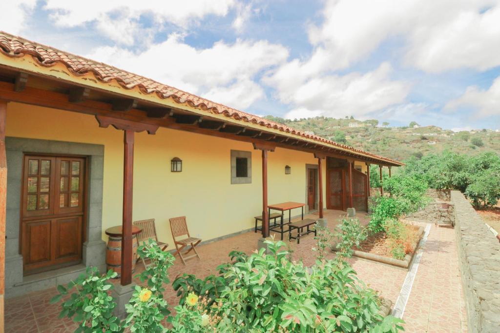 a house with a patio with chairs and tables at Countryside Views House Teror in Teror