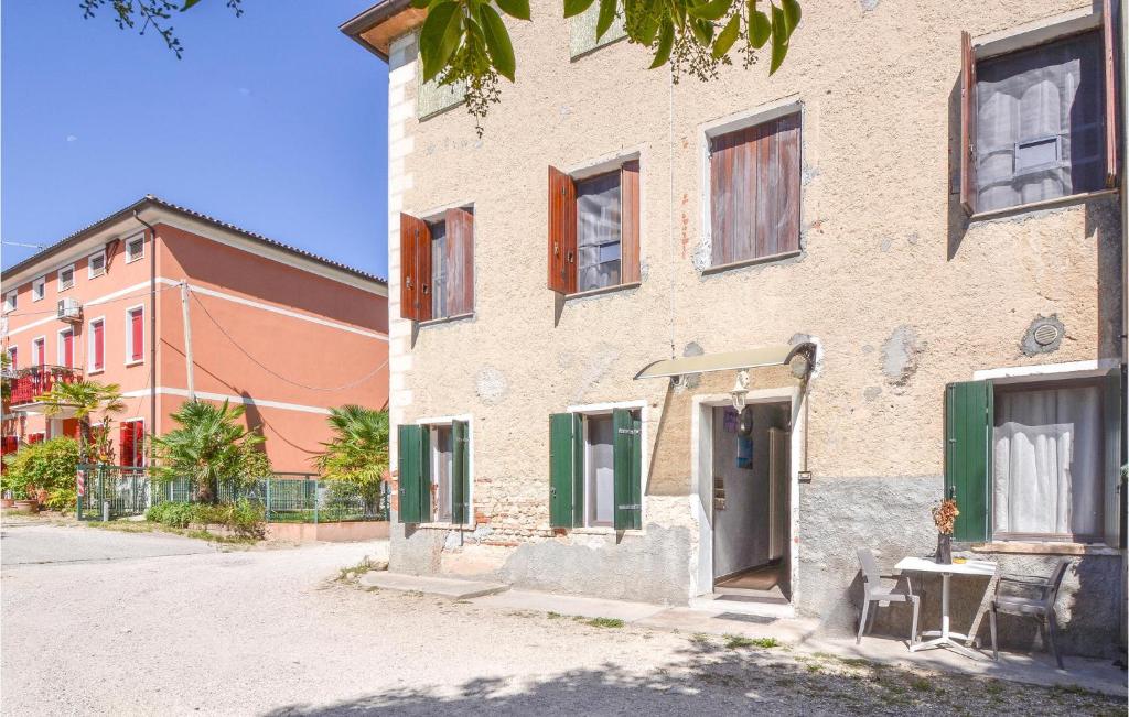 un bâtiment en briques avec volets verts dans une rue dans l'établissement Gorgeous Home In San Zenone D, Ezzelini With Kitchen, à Fonte