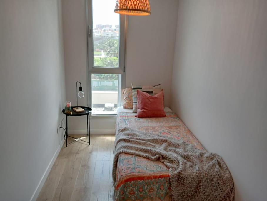 a bedroom with a bed with a pillow and a window at Casa Arirni in Las Palmas de Gran Canaria