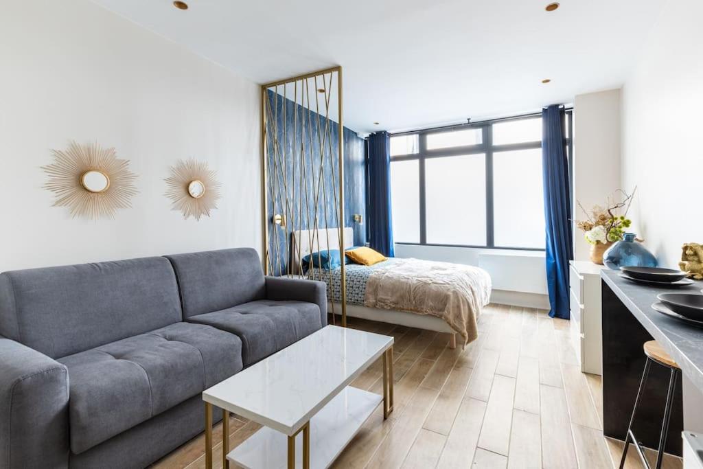 un salon avec un canapé et un lit dans l'établissement Chaudron/La Fayette Canal St-Martin Cosy Studio 4P, à Paris