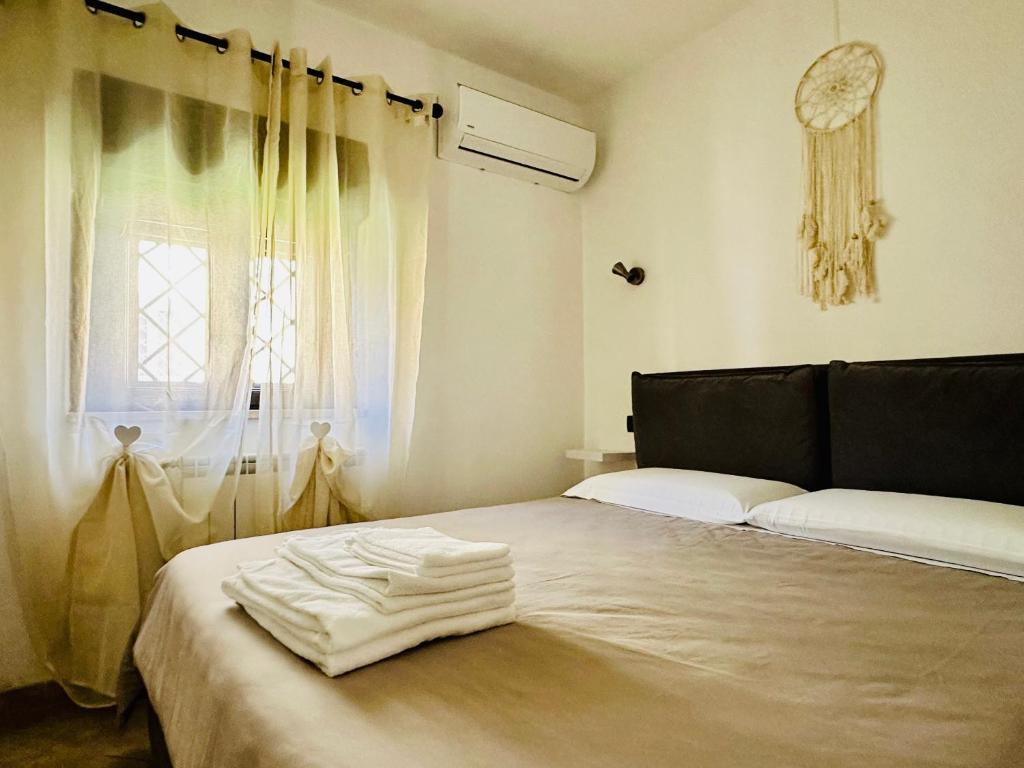 1 dormitorio con 1 cama con sábanas blancas y ventana en La casetta di Giulio II, en Ostia Antica