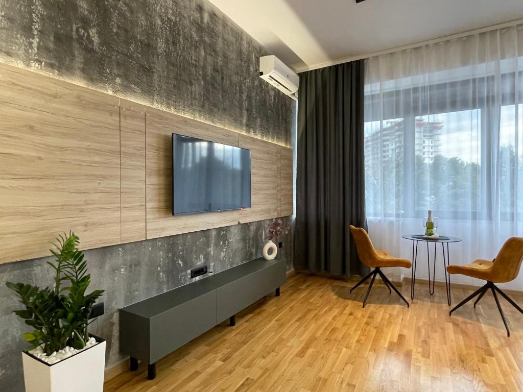 uma sala de estar com uma televisão na parede em Elite Central Suites em Skopje