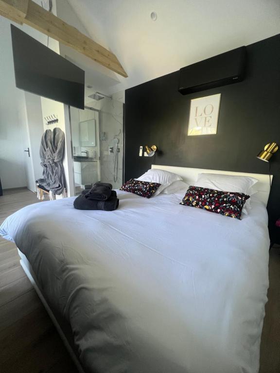 a large white bed with two pillows on it at Suite romantique avec Spa et filet suspendu in Auteuil