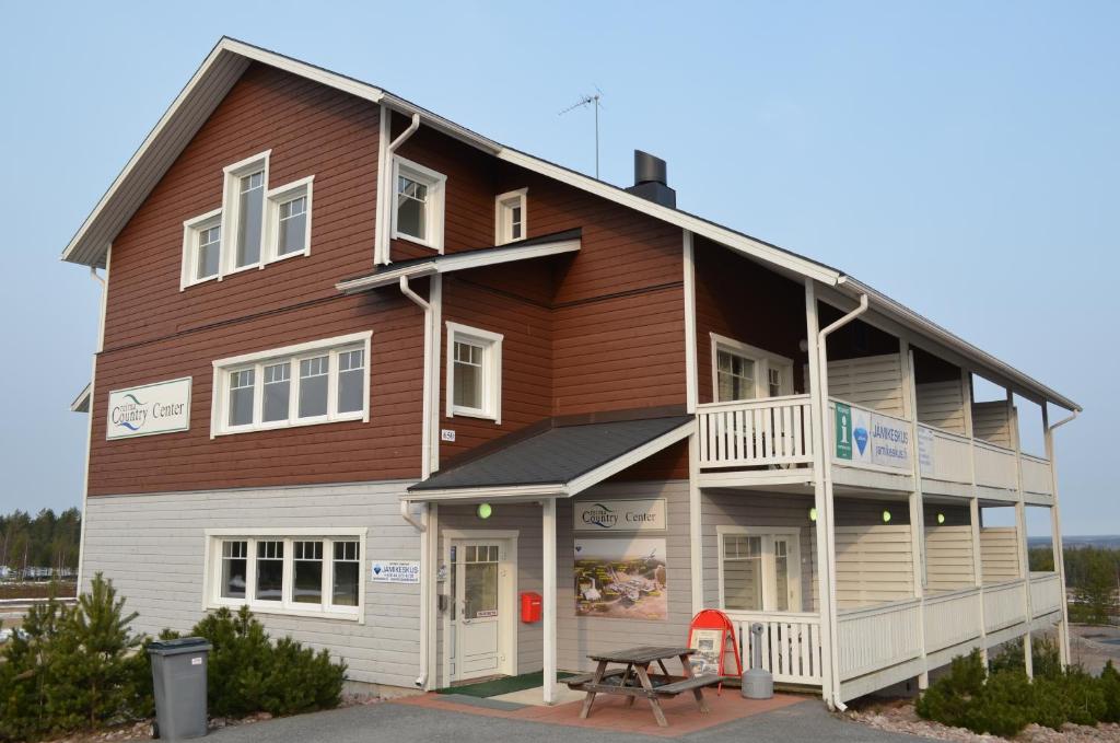 a large wooden building with a picnic table in front of it at Hotel Reima Country Center in Jämijärvi
