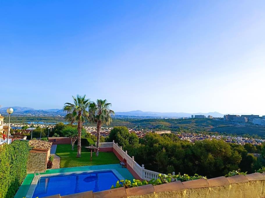 een villa met een zwembad en uitzicht op de stad bij Adosado cerca de la playa in Gran Alacant