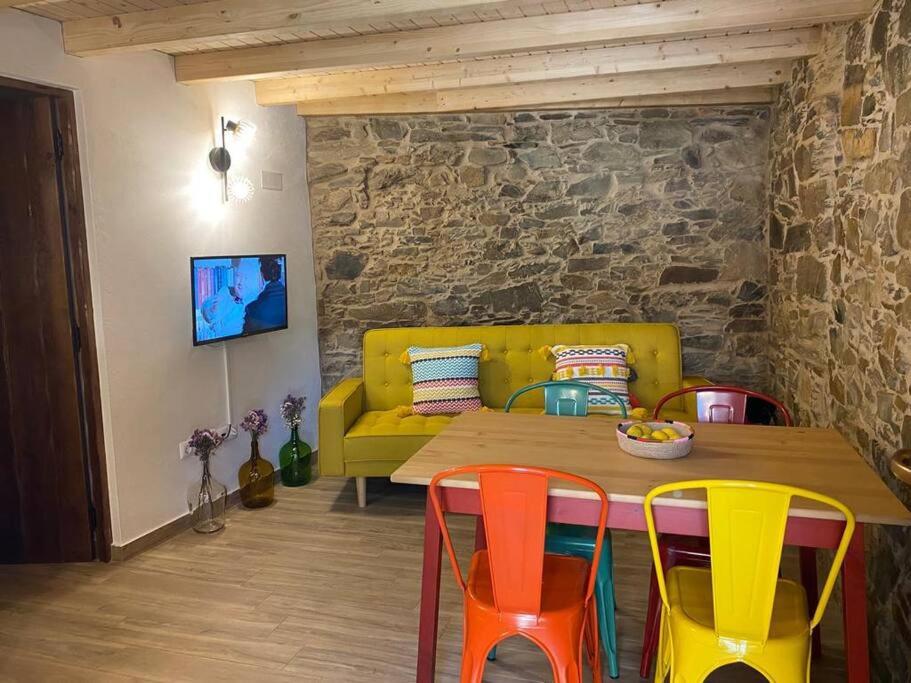 een eetkamer met een houten tafel en kleurrijke stoelen bij Casa do Tear in Sobreira Formosa