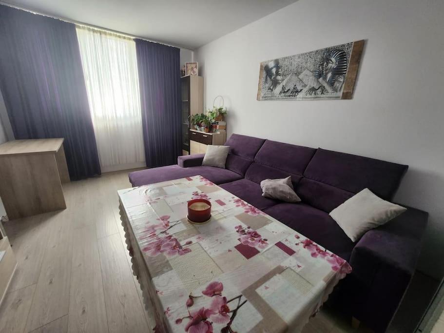 a living room with a purple couch and a table at Modern apartment. Best location in Sofia