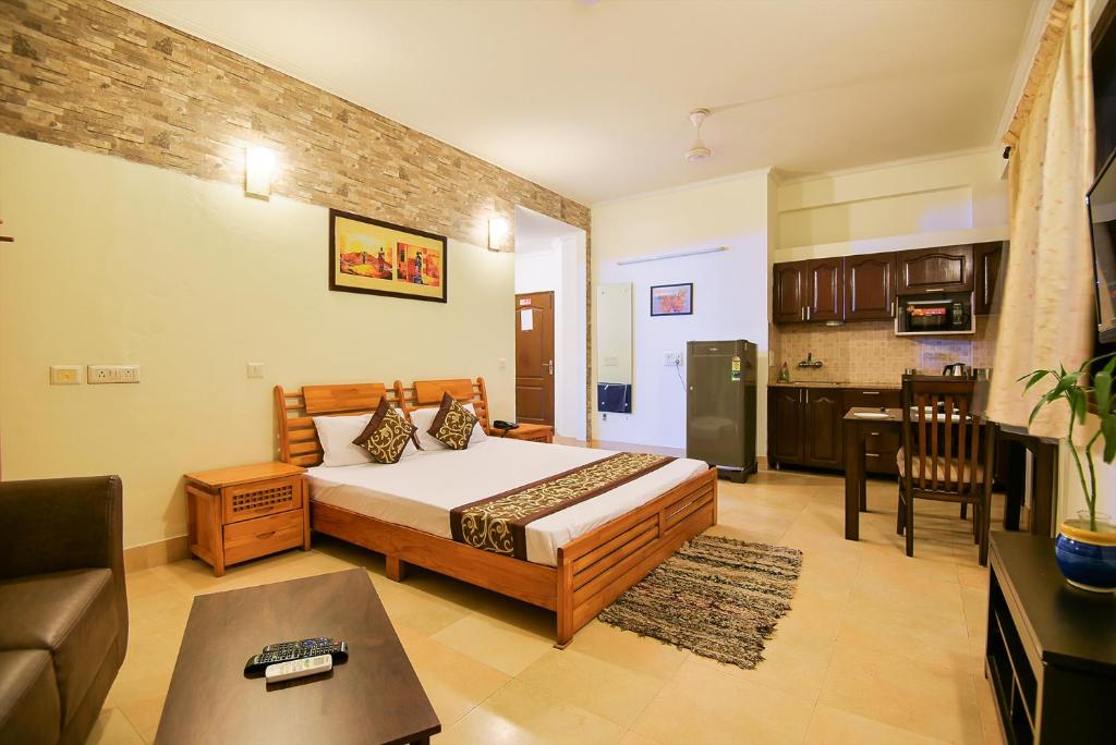 een slaapkamer met een bed en een woonkamer bij BedChambers Serviced Apartments, Sushant Lok in Gurgaon