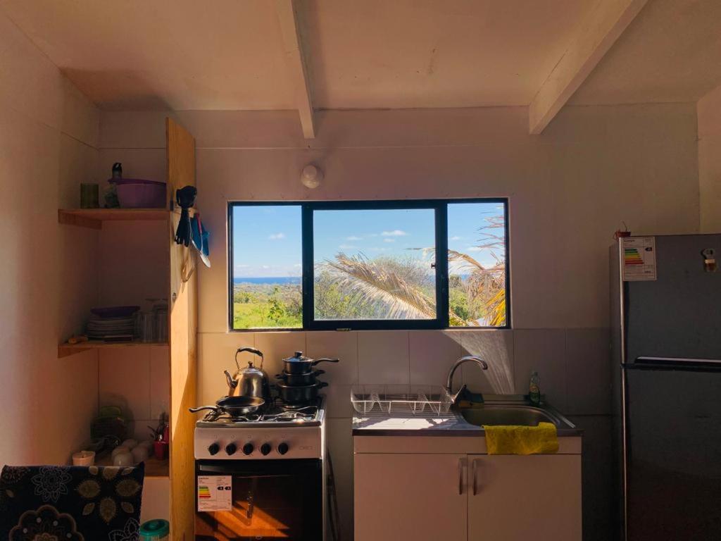 een keuken met een fornuis en een raam erin bij Pua vaenga in Hanga Roa
