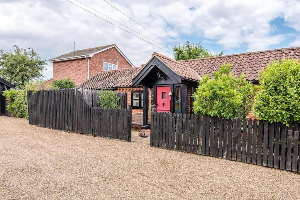 a house with a wooden fence in front of it at Long Barn, Wrentham in Beccles