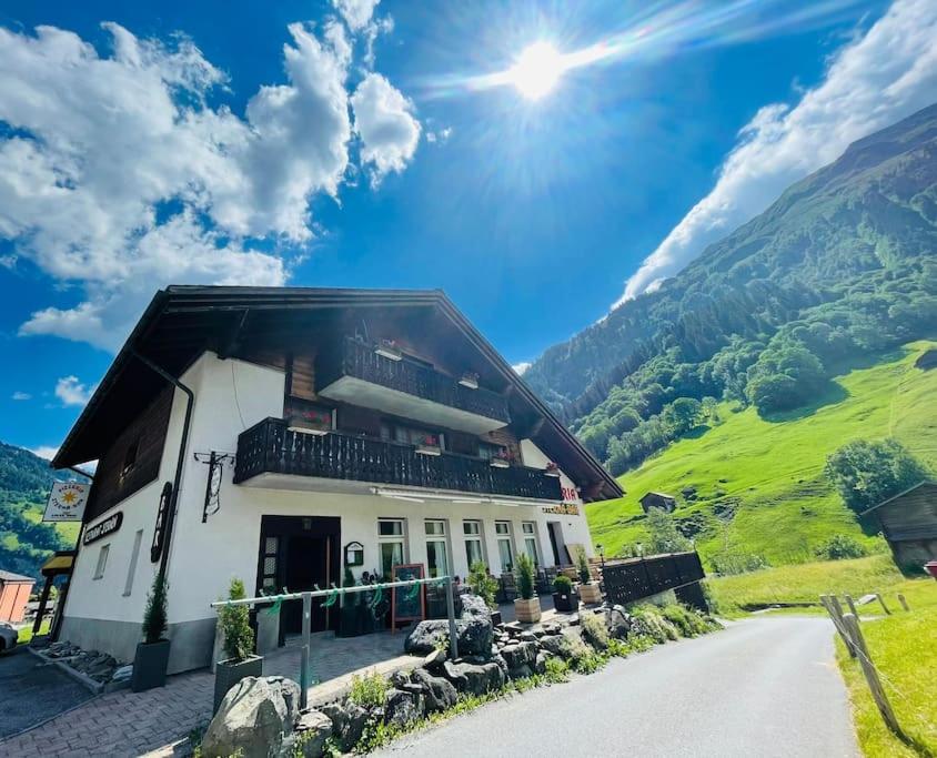 a house on a hill with a road next to it at Sternen B&B & Ristorante in Elm