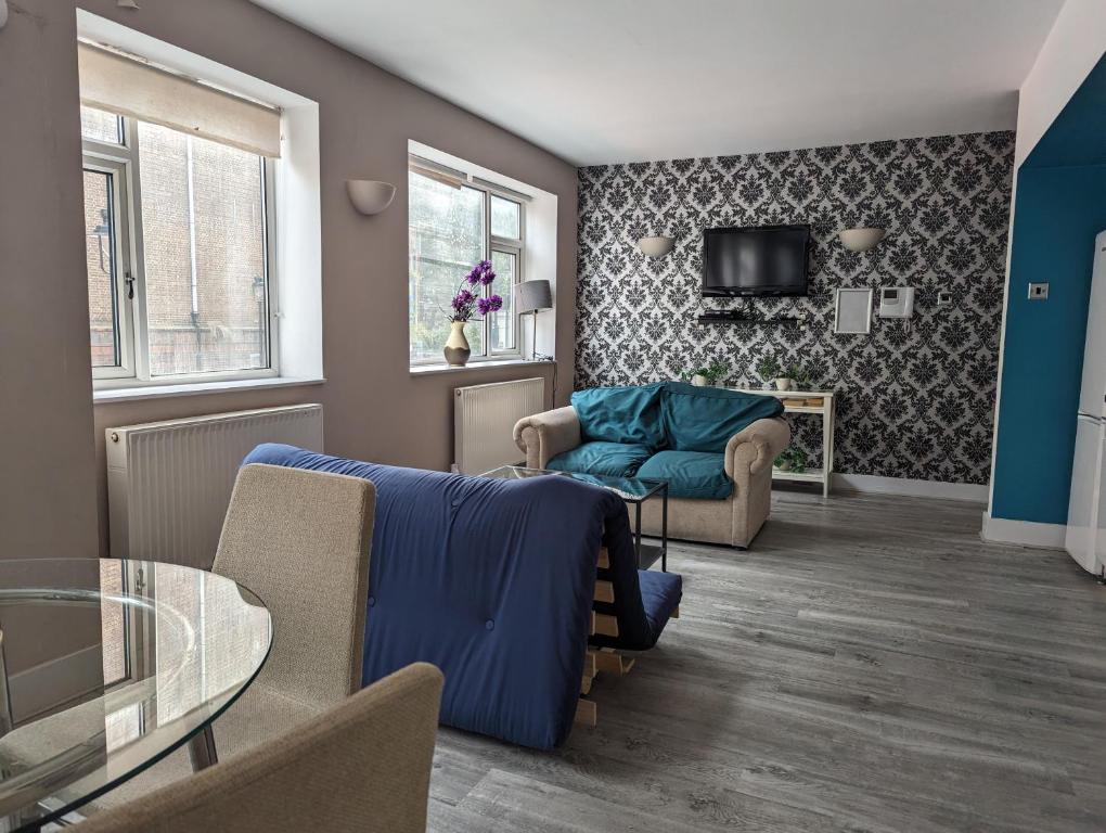 ein Wohnzimmer mit einem blauen Sofa und einem Tisch in der Unterkunft Flat In Camden Town in London