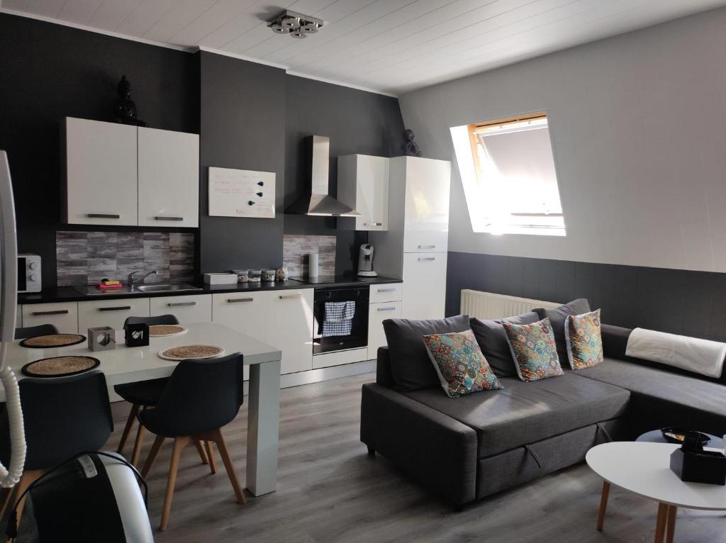 een woonkamer met een bank en een keuken bij Escale in Luik