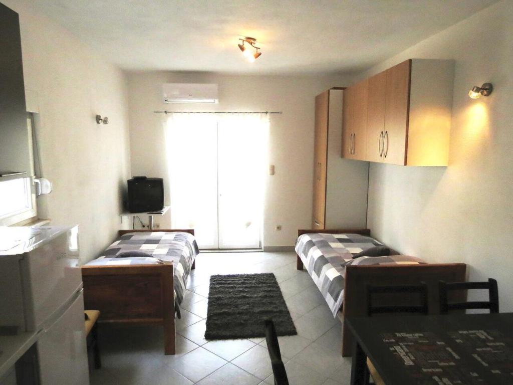 Habitación pequeña con 2 camas y ventana en Apartments Ljubičić en Podstrana