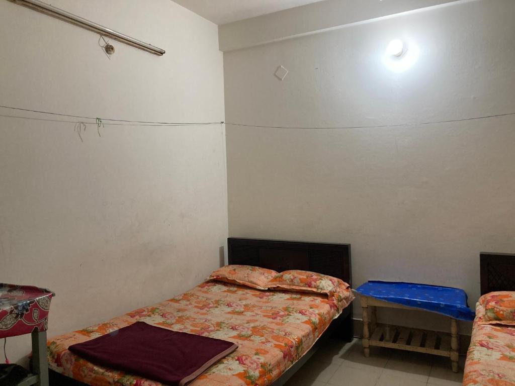 a room with two beds and a table in it at Hotel Surma Residential in Dhaka