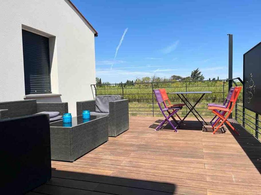 un patio avec des chaises et une table sur une terrasse dans l'établissement Tierra Del Viento - Villa Proche de la Mer, à Peyriac-de-Mer