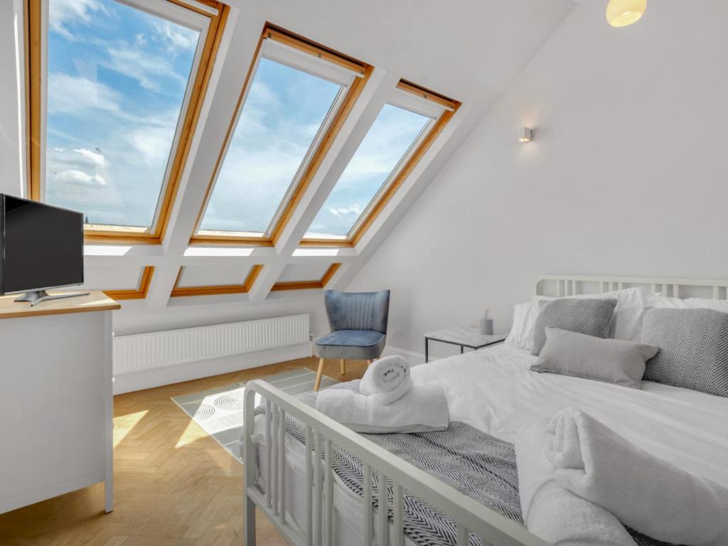1 dormitorio con 1 cama, TV y ventanas en Pass the Keys Luxury Townhouse In The City en Canterbury