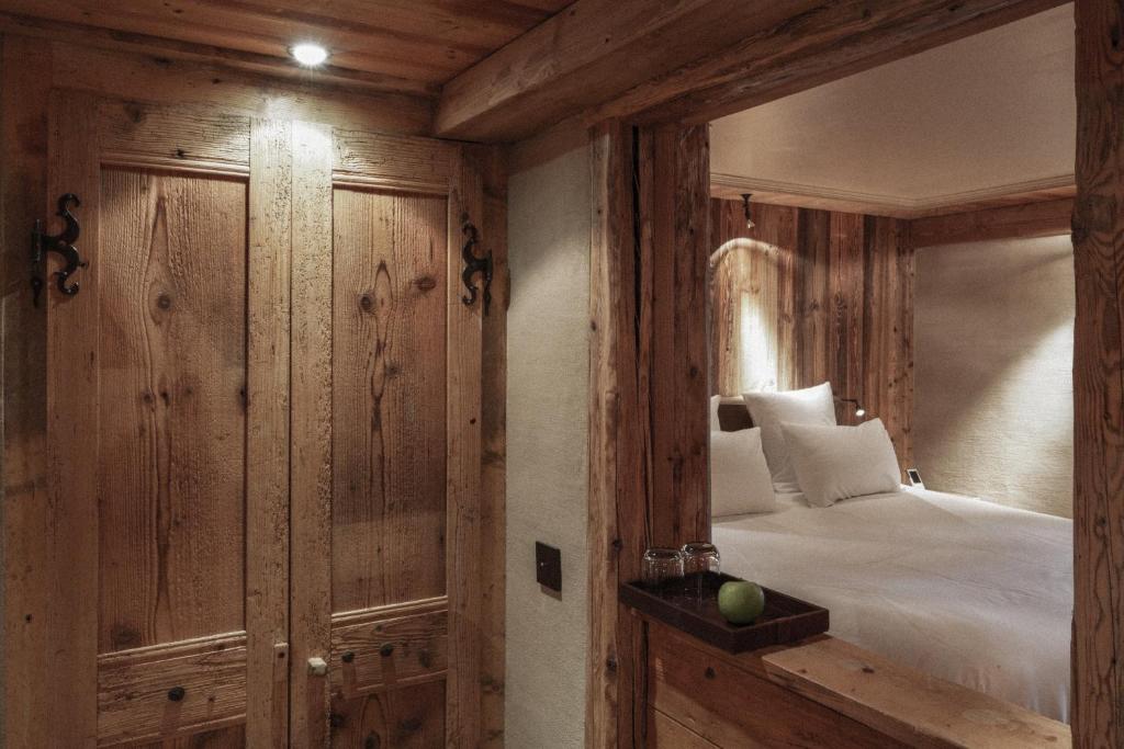 a bedroom with a bed and wooden walls at Zannier Hotels Le Chalet in Megève