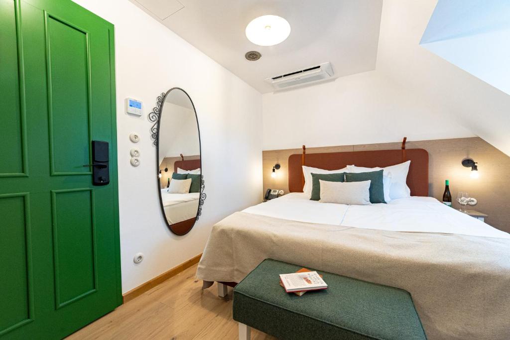 ブダペストにあるCzakó Bed&Breakfastの緑のドアとベッド付きのベッドルーム1室