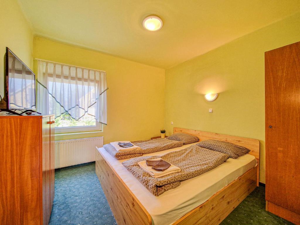 a bedroom with a bed and a window at Lepke Apartman in Harkány