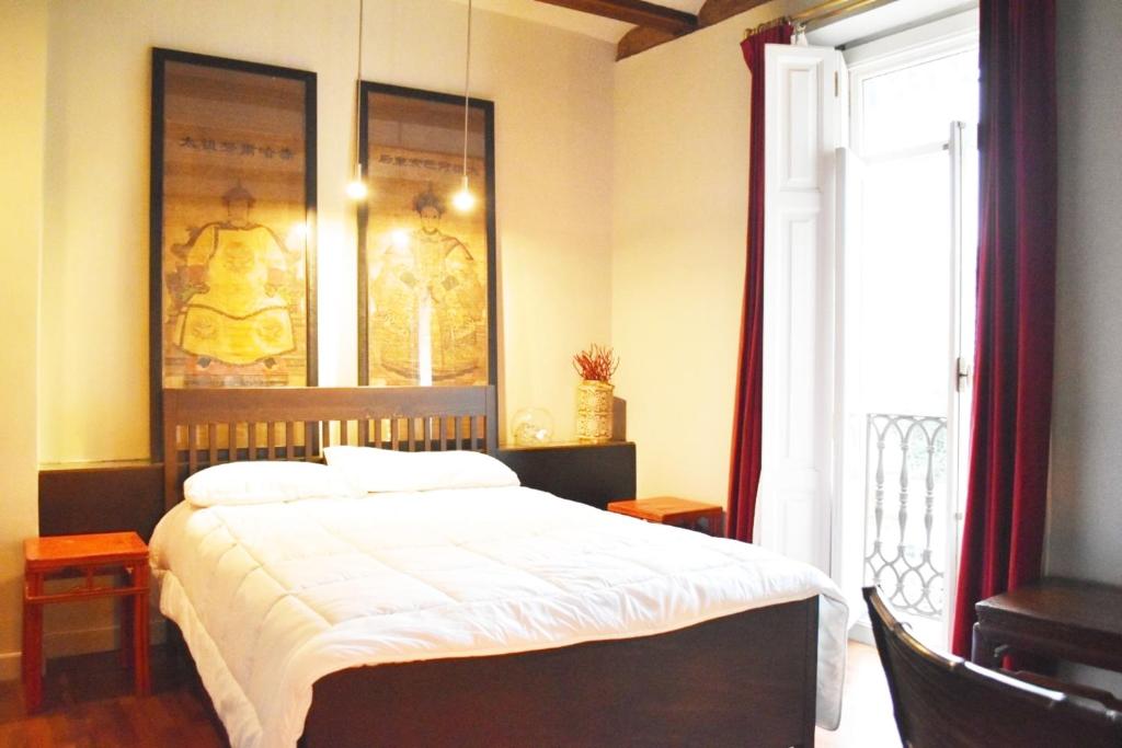 um quarto com uma cama e uma grande janela em Estudio Ciutat Vella al lado de Jardines del Turia em Valência
