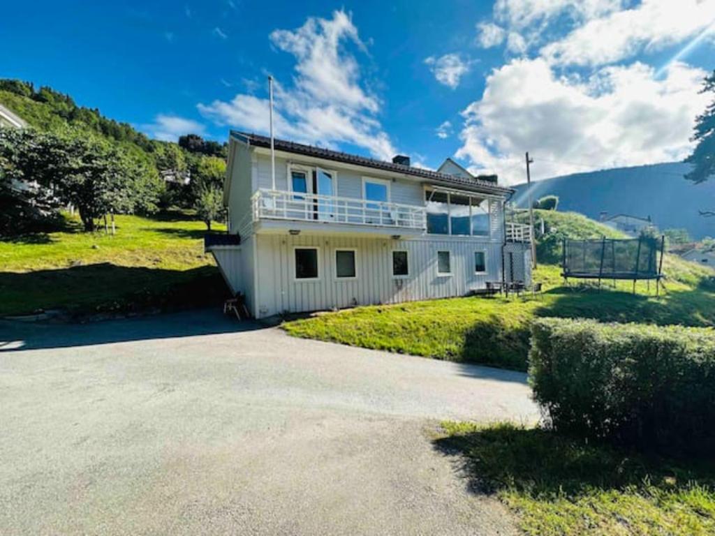a white house with a balcony on a hill at Prestadalen 6 in Sogndal
