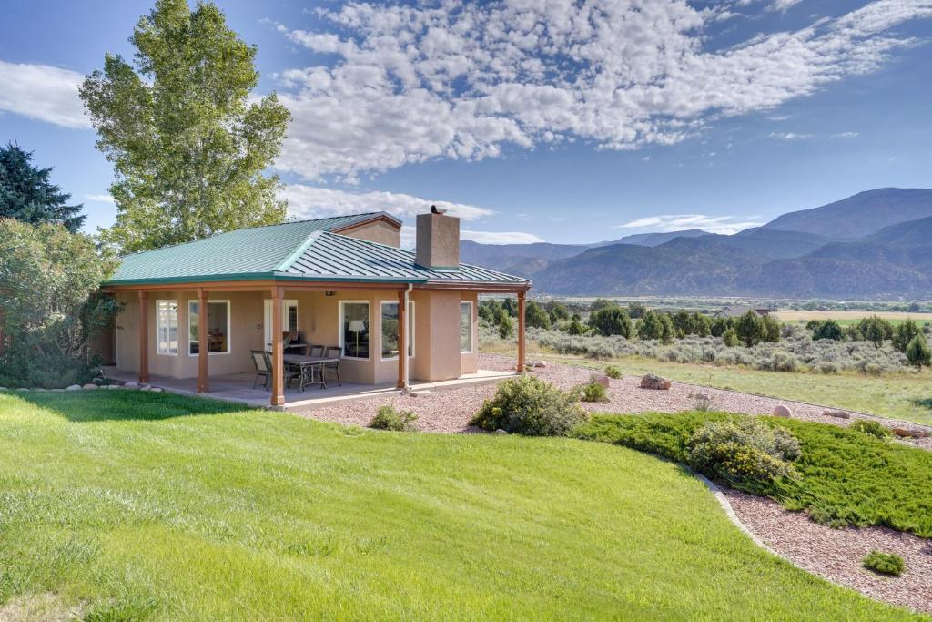 uma pequena casa numa colina com montanhas ao fundo em Zion Mountain Guest House with Canyon Vistas! em New Harmony