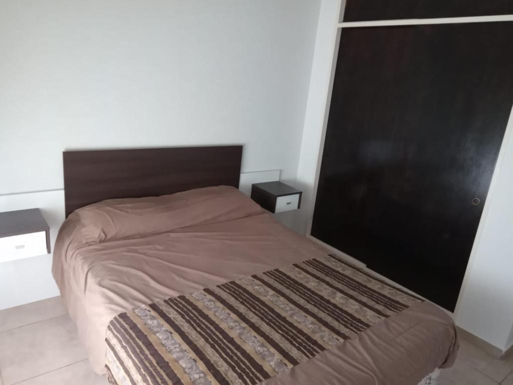 een bed in een kamer met 2 nachtkastjes en een bed sidx sidx sidx bij Departamento en Morón in Morón
