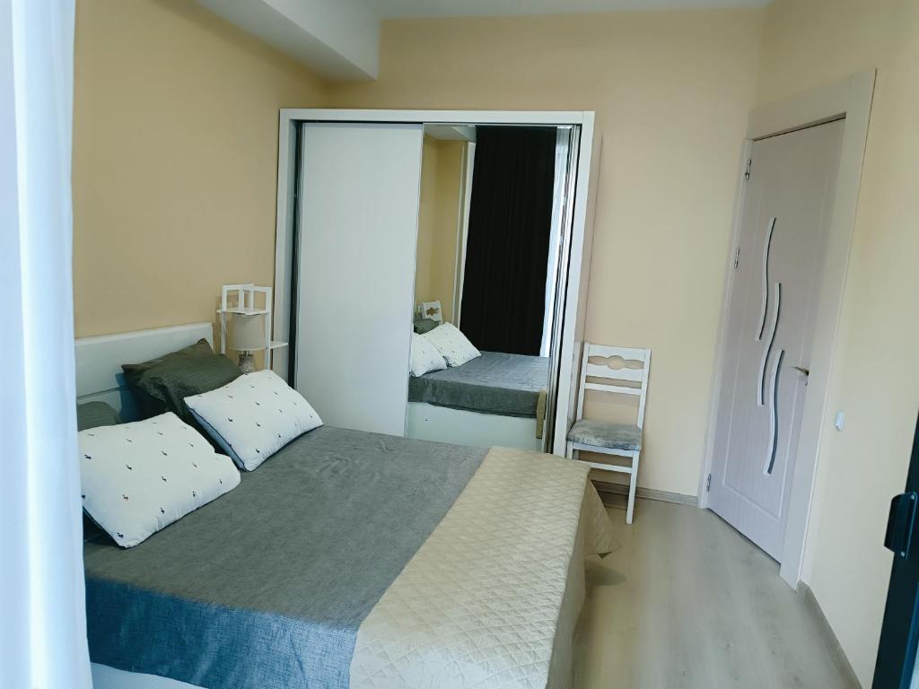 een slaapkamer met een groot bed en een spiegel bij Vake Residence cloze to Park Mziuri in Tbilisi City