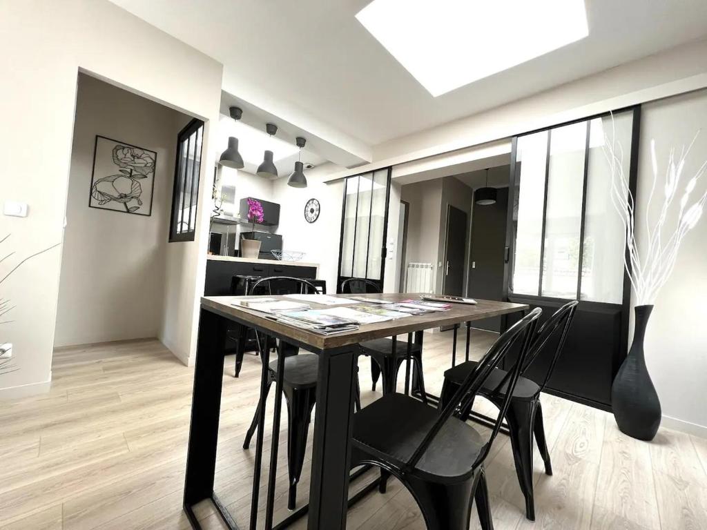 a dining room with a black table and chairs at Manhattan, Appartement calme in Reims