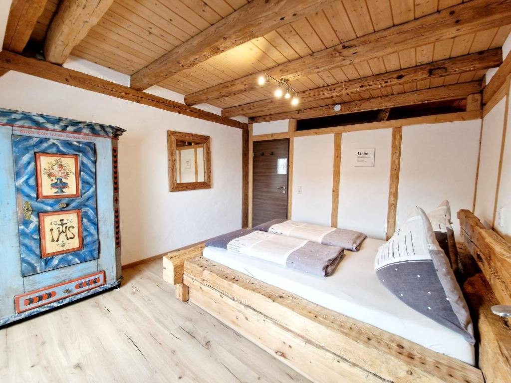 a bed in a room with a wooden ceiling at Wood & Stone Lodge 1 in Donaueschingen