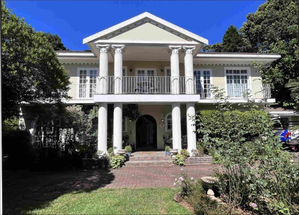 a large white house with columns and a balcony at Bancroft B&B in Hilton