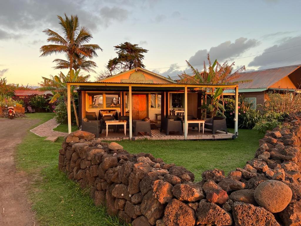 a house with a stone wall in front of it at Hotel Boutique La Perouse in Hanga Roa