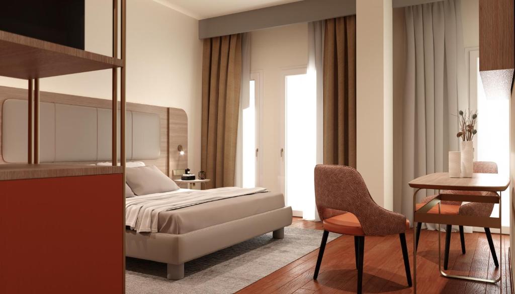 um quarto com uma cama, uma mesa e uma cadeira em Hotel Raffaello em Milão