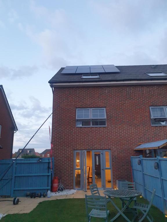 una casa in mattoni con pannelli solari sul tetto di Burton House 