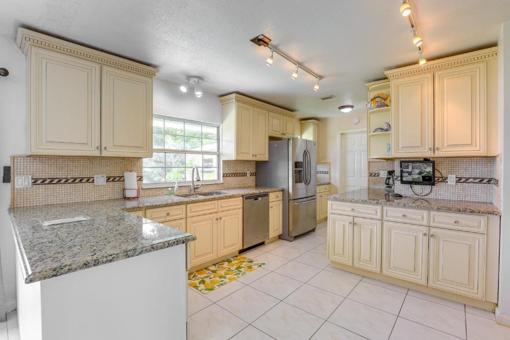 a large kitchen with wooden cabinets and granite counter tops at Port St Lucie Vacation Rental 9 Mi to Beach in Port Saint Lucie