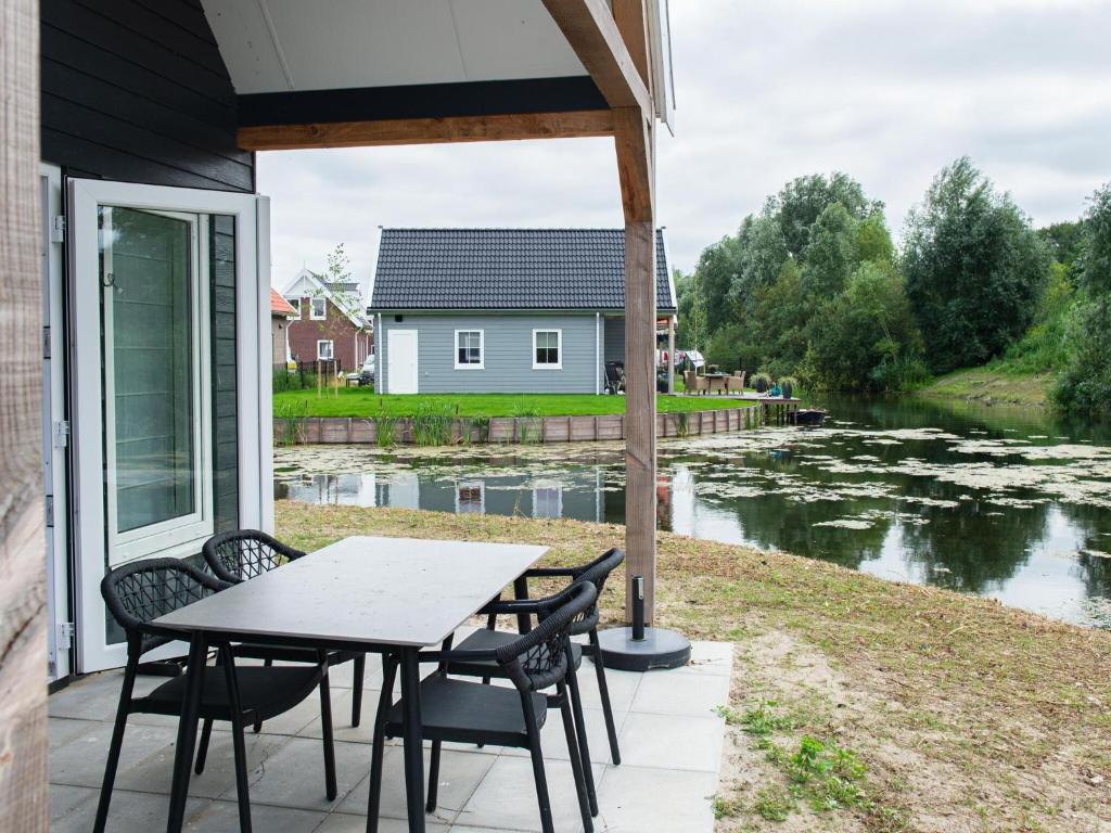 een patio met een tafel en stoelen naast een rivier bij Nice holiday home in Simonshaven with garden in Simonshaven