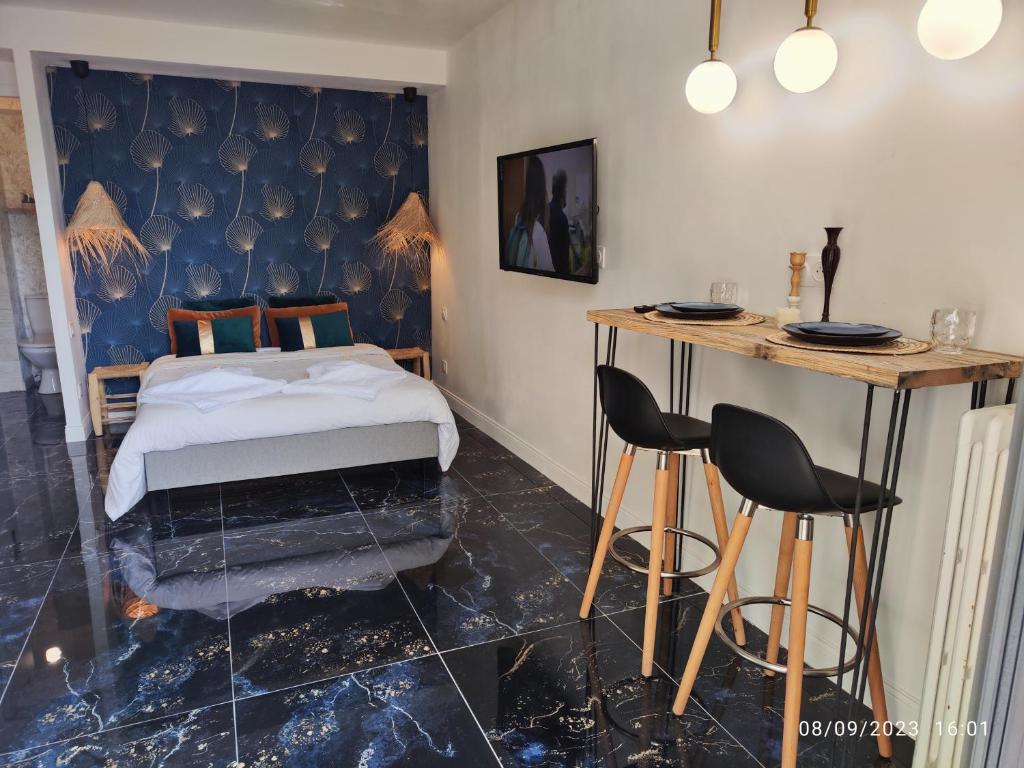 1 dormitorio con 1 cama, mesa y sillas en Studio avec jaccuzzi en Saintry-sur-Seine