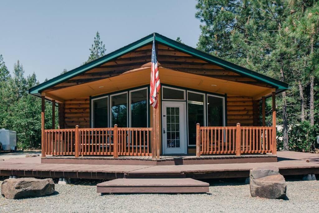 una cabaña de madera con bandera americana en un porche en The Lodge, 