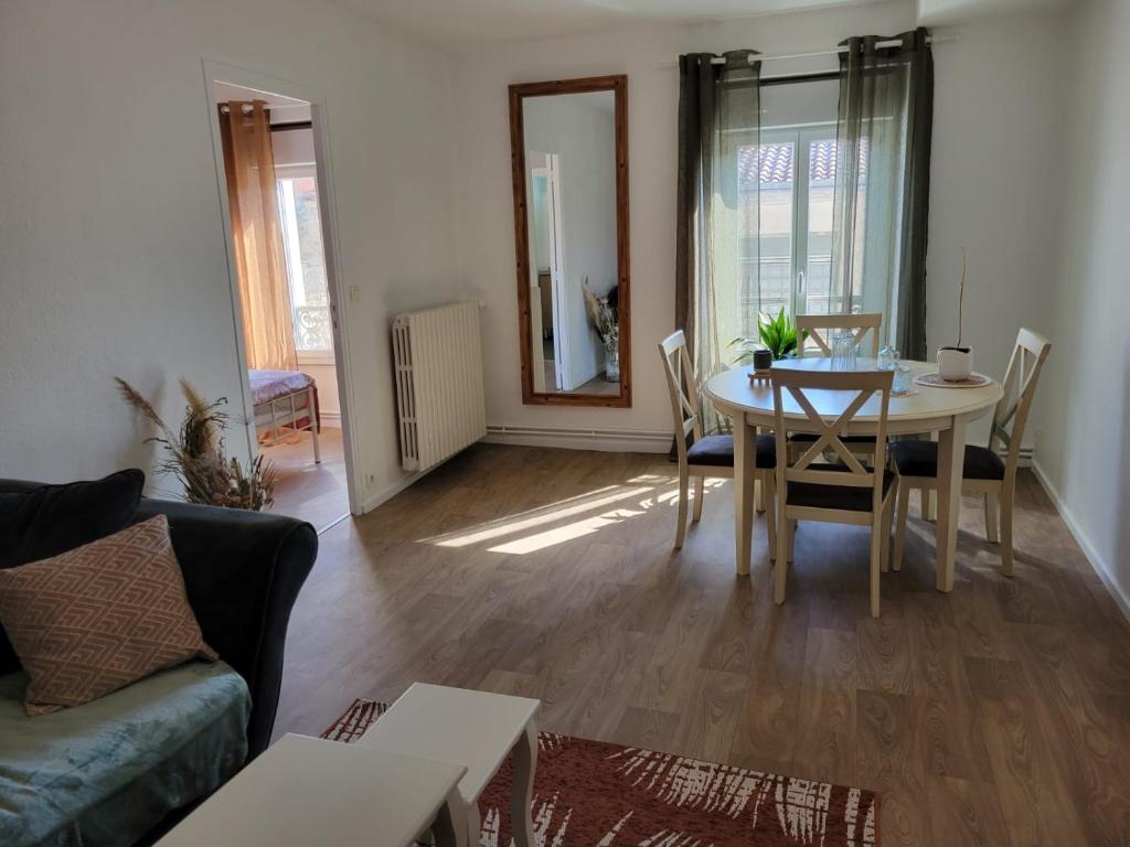 a living room with a table and a couch at Bel appartement hyper centre, 3 pièces 60m² in Périgueux