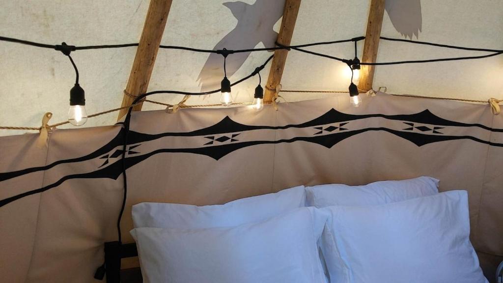 a bedroom with a tent with white pillows and lights at Ravens Myth - Luxury Glamping - Sleeps 2 