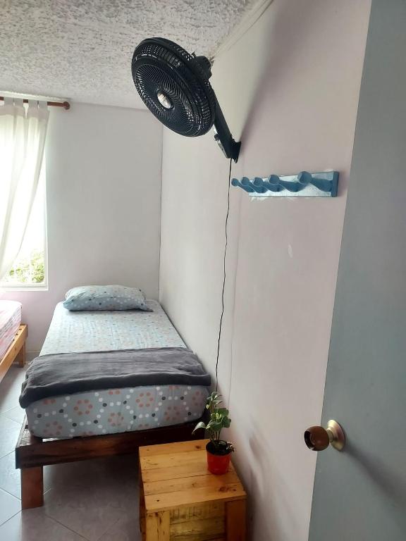a small bedroom with a bed and a window at Tatami Hostel in Bucaramanga
