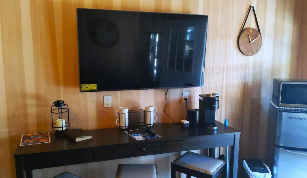 a room with a table with a television on a wall at Lazy Bear Cabin 6 - Sleeps Up To 4 
