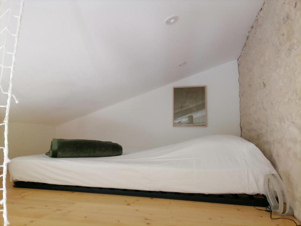 ein Schlafzimmer mit einem weißen Bett in einem Zimmer in der Unterkunft Studio 2 à 4 personnes in Dompierre-sur-Mer
