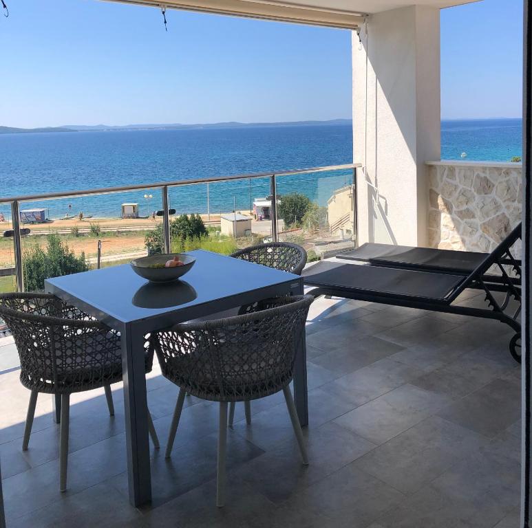 una mesa y sillas en un balcón con vistas al océano en Apartments Kovacev, en Zadar