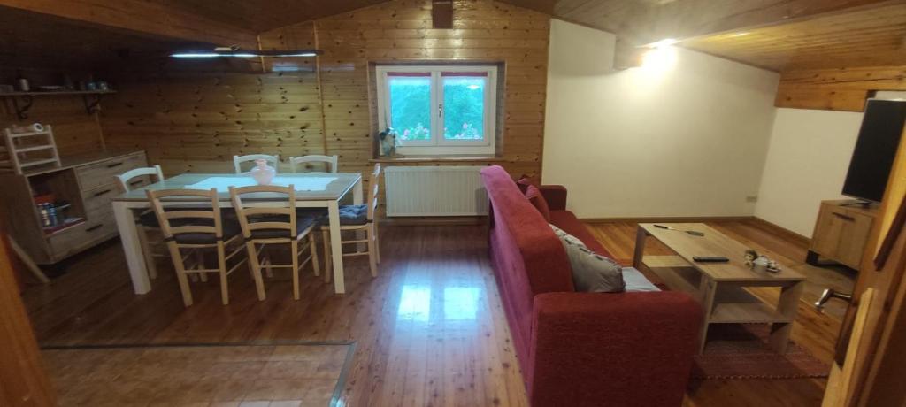 a living room with a table and chairs and a dining room at A&J House in Canale San Bovo