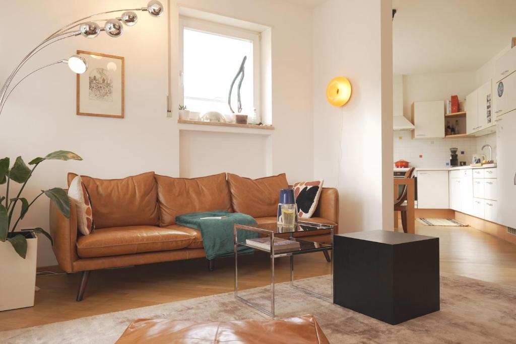 a living room with a brown couch and a table at Stylish hideout - mountain view in Brixen