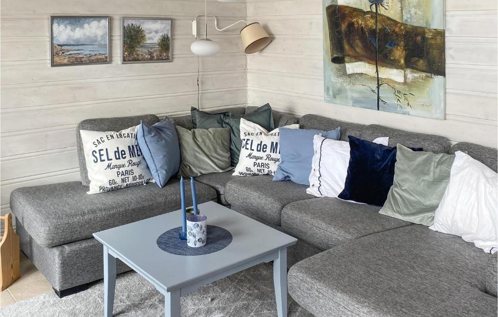 ein Wohnzimmer mit einem Sofa mit Kissen und einem Tisch in der Unterkunft 3 Bedroom Stunning Home In Gressvik in Gressvik