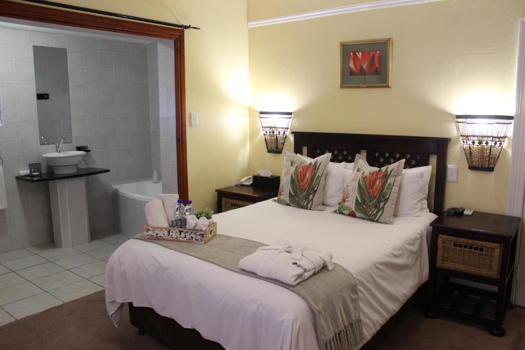 a bedroom with a large bed and a bathroom at Royal Guest House in Port Alfred